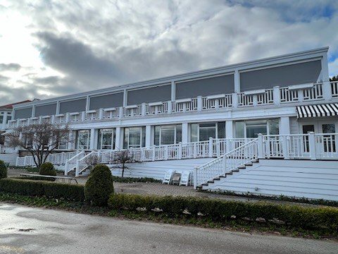 White waterfront venue with screened outdoor seating