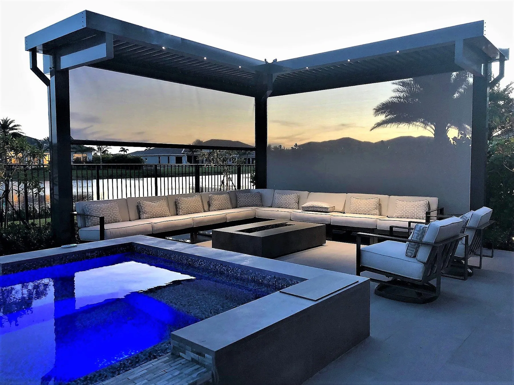 Pergola patio by a pool at sunset with screens lowered