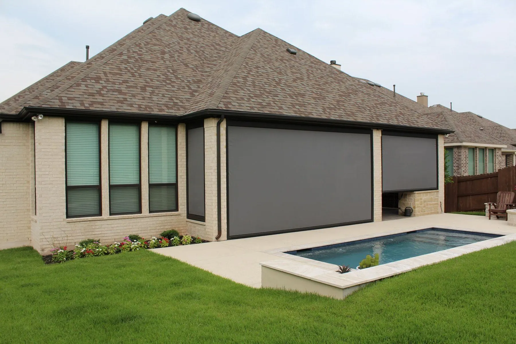 Poolside home with wide dark screens enclosing the covered patio